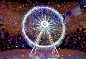 Photo vibrante capturant la roue d'anniversaire Google, tournant parmi un flou de confettis et de ballons sur un fond de guirlandes festives.